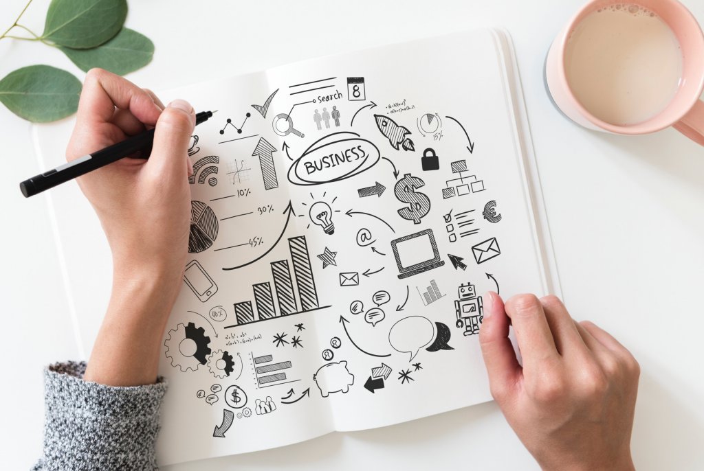 social media strategy - hands of a woman writing something in a notebook