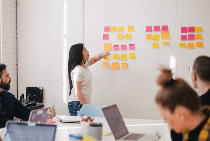 smarketing people using sticky notes having a meeting in a room asian european